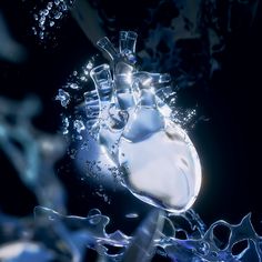 a heart - shaped object floating in water with bubbles and splashing liquid around it