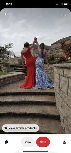 two women in dresses are standing on some steps