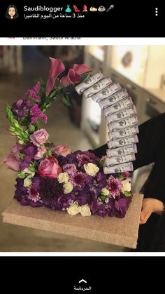 a woman holding a bouquet of flowers and money in front of her face with the letter e on it