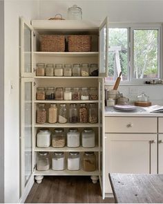 an organized pantry with glass jars and baskets