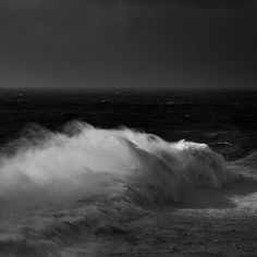 a black and white photo of waves crashing on the beach