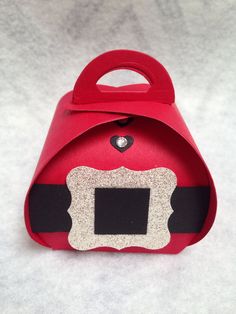 a red paper bag with a black and white design on the front is sitting on a table