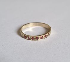 Solid gold Garnet half eternity ring, Garnet stacking ring, stacking gemstone rings, January birthstone ring, Garnet gold ring Solid gold, handmade half eternity stacking ring, stoned with 7 beautiful deep red gemstones.  This multistone ring is beautiful alone or stacked together with other rings and is colorful and pretty on your finger.  The ring is available in 9k or 14k solid gold- yellow, white or rose. It is also available in nickel free, 14 karat gold plating over brass or silver and in solid sterling silver.  A perfect engagement ring or just a beautiful gift for you.  Dimensions: The ring width is about 2 mm. Multiple ring sizes are available. if you need an additional different sizes just convo me. The price is for one ring. For other rings I make: https://www.etsy.com/il-en/sho Garnet Gold Ring, Multistone Ring, January Birthstone Rings, Garnet And Gold, Etsy Gold Ring, Half Eternity Ring, Red Gemstones, Ring Stacking, January Birthstone