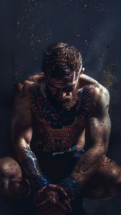 a man with tattoos sitting on the ground