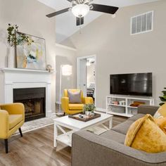 a living room filled with furniture and a flat screen tv mounted on a wall next to a fire place