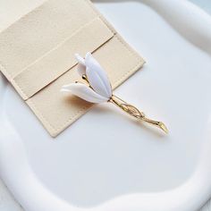 Indulge in pure sophistication with our Elegant White Tulip Brooch. Crafted with exquisite detail, this brooch adds a touch of luxury to any outfit.
Its delicate white tulip design exudes elegance and grace, making it the perfect accessory for any special occasion.
Elevate your style and make a statement with this exclusive piece. Luxury White Pins For Gifts, Luxury White Elegant Brooches, Luxury White Flower Brooches, Tulip Design, White Tulips, Mother's Day Gift, Tulips, Mother's Day Gifts, Mothers Day