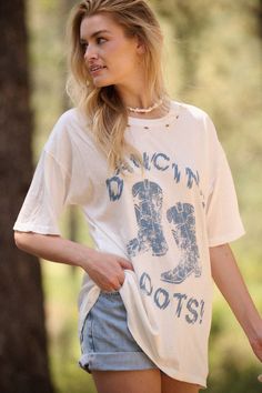 Distressed, garment washed graphic t-shirt. Vintage-style "Dancing Boots!" text print with cowboy boots graphic. Torn and distressed detailing at neckline, cuffs, and hem. Round neckline. Short sleeves. Drop shoulder. Oversized fit. 100% Cotton. Imported top designed and printed in LA. Model wears size S. Cowboy Boots Graphic, Oversize Graphic Tee, Dance Boots, Distressed Tee, Oversized Graphic Tee, Text Print, Tiered Maxi Dress, Modern Fashion, Star Fashion