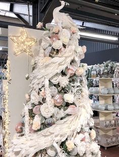 a white christmas tree in a store with lots of lights and ornaments on it's sides