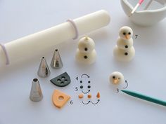 the tools needed for making snowmen are displayed on a white surface with markers and pencils