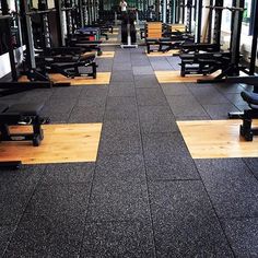 an empty gym with rows of benches on the floor and one person standing in the background