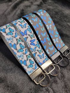 a pair of scissors sitting on top of a gray cloth with blue and white butterflies