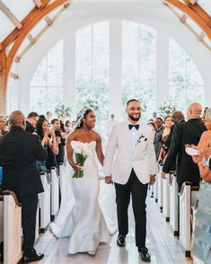 a bride and groom walking down the aisle