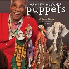 an older man is sitting in front of some stuffed animals and smiling at the camera