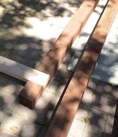 two wooden benches sitting next to each other on top of a cement floor covered ground