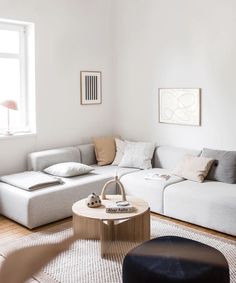 a living room filled with furniture and a large white couch in front of a window