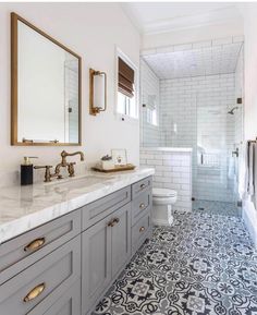 a bathroom with gray cabinets and white walls