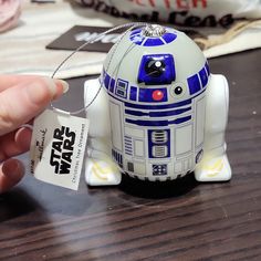 a star wars character ornament being held by someone's hand with a tag attached to it