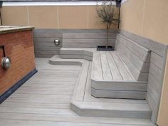 a wooden bench sitting on top of a hard wood floor next to a planter