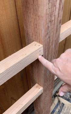 a person is pointing at some wood planks