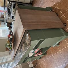 the kitchen counter is made out of wood and has green drawers on each side, along with an oven