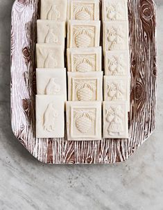 some white chocolates sitting on top of a metal tray with brown and white designs