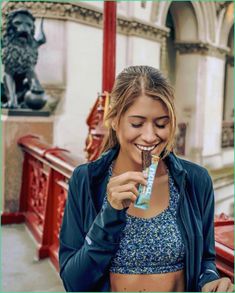 a woman is smiling and holding a toothbrush