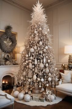 a white christmas tree in a living room next to a fire place and couches