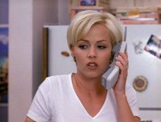 a woman talking on the phone in her kitchen