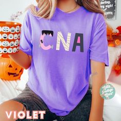 a woman wearing a purple t - shirt with the word cna printed on it