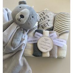 a teddy bear wrapped in blankets with a tag on it's chest and label attached to the blanket