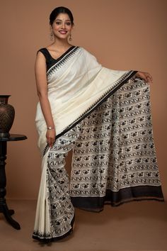 Everyone's favorite white and black saree is back in Ramdhanu's collection, a Soft silk saree with Madhubani style hand block printing.  WEIGHT: 350 g COLOUR: White and black CRAFT: Hand Block printing DIMENSIONS: Saree length 6.5 Mts., Saree width 1.14 Mts. Blouse piece inclusive. PATTERN: Madhubani motif PRODUCT MATERIAL: Handwoven Mulberry Pure Silk saree PRODUCT TYPE: Saree with Blouse piece WASH INSTRUCTIONS: Dry Clean recommended for this product. Iron inside out. Do not bleach and expose this product to excessive heat and sunlight for long. White And Black Saree, Black White Saree, Block Sarees, Black Cotton Saree, Indigo Saree, Draping Styles, Ladylike Dress, Black Craft