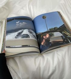 an open book on a bed with a man in a car and palm trees behind it