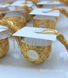 graduation decorations made out of gold foil and white paper are displayed on a table top