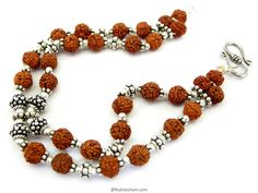 There are 3 designs of the 5 Mukhi Rudraksha Bracelets to choose from. All the bracelets have two strands. Choose your style. Design 1 : single big silver bead in center. Design 2 : two big silver beads in center with Strands of rudraksha beads. Design 3 : there are 4 small silver beads in the center with rudraksha and silver accessories. Bracelet Details : This Bracelet is made of small 5 Mukhi Rudraksha Beads of size 6 mm strung in strong thread with silver accessories and a hook. Note : The s 5 Mukhi Rudraksha, Rudraksha Bracelet, Rudraksha Beads, Beads Design, Wrist Mala, Designer Bracelet, Silver Accessories, Silver Bead, Prayer Beads