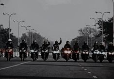 a group of motorcyclists riding down the street in formation on their bikes