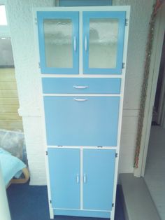 a blue and white cabinet sitting in the corner of a room