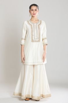 Ivory kurta with lace and mirror embroidery. Paired with a gharara and pink, ivory ombre dupatta and lace border. - Aza Fashions White Palazzo Set With Gota Work For Eid, Eid White Palazzo Set With Gota Work, Elegant Off White Palazzo Set With Gota Work, White Silk Kurta With Mirror Work, White Raw Silk Sets With Mirror Work, White Raw Silk Eid Set, Elegant Cream Palazzo Set With Gota Work, White Raw Silk Set For Eid, Elegant Cream Sets With Dori Work