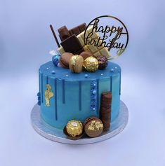 a blue birthday cake with chocolates on top