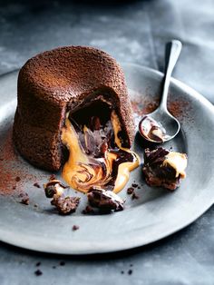 a chocolate cake with ice cream and caramel sauce on it sitting on a plate