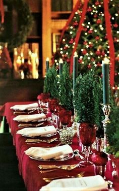 a long table set with place settings and christmas decorations