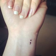 a woman's hand with a small tattoo on it