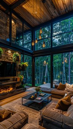 a living room filled with lots of furniture next to a fire place and large windows