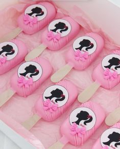 pink and black cupcakes in a box with stickers on them that say cat