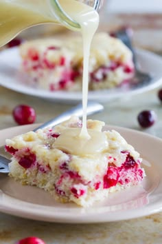 cranberry cheesecake being drizzled with icing on a plate