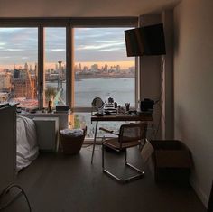 a bedroom with a large window overlooking the water and cityscape in the distance