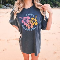 Embrace the tropical vibes and VSCO-inspired style with the Comfort Colors "Aloha Hibiscus" Shirt. This trendy tee is a summer essential, perfect for beach days and sunny adventures. With its hibiscus flower design and beachy aesthetic, it adds a touch of tropical fashion to your wardrobe. Let the vibrant colors and beach vibes transport you to paradise. All clothing and accessories from The Southern Thistle are handmade-to-order, just for you! ☺️ Experience the epitome of comfort with Comfort C Cotton Hawaiian Shirt With Hibiscus Print For Vacation, Hawaiian Hibiscus Print Shirt For Vacation, Hawaiian Shirt With Hibiscus Print For Vacation, Summer Hawaiian Shirt For Surfing, Tropical Hawaiian Shirt With Hibiscus Print For Beach Season, Multicolor Hawaiian T-shirt For Beach Season, Beachy Hawaiian Shirt With Tropical Print, Cotton Hawaiian Shirt With Hibiscus Print For Beach, Beachy Tops With Tropical Print And Relaxed Fit