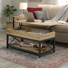 a living room with a couch, coffee table and laptop computer on top of it