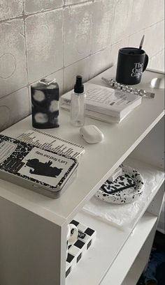 a white desk topped with two laptops next to a cup and saucer on top of it