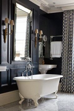 a white bath tub sitting under a bathroom mirror