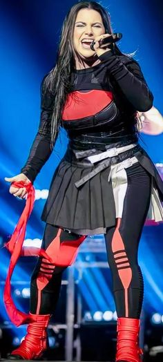 a woman in black and red outfit on stage